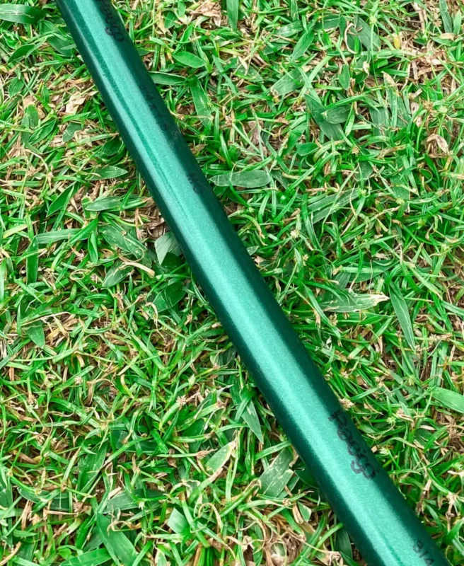 Mangueira jardim sustentável EcoPérola deitada na grama representando o seu uso diário.